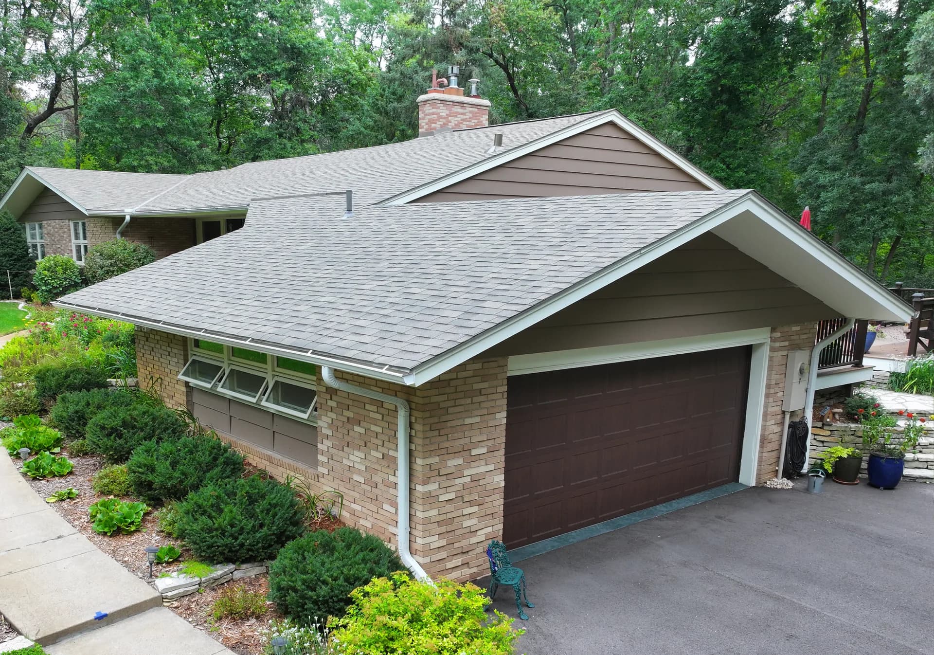 Light gray shingle roof above a brick home and attached garage