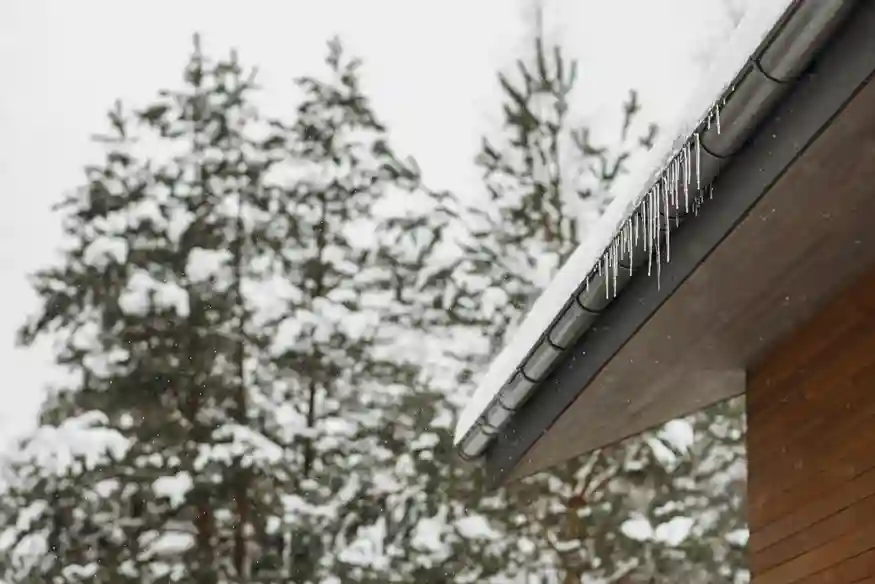 Snow-covered roof with icicles forming in winter.