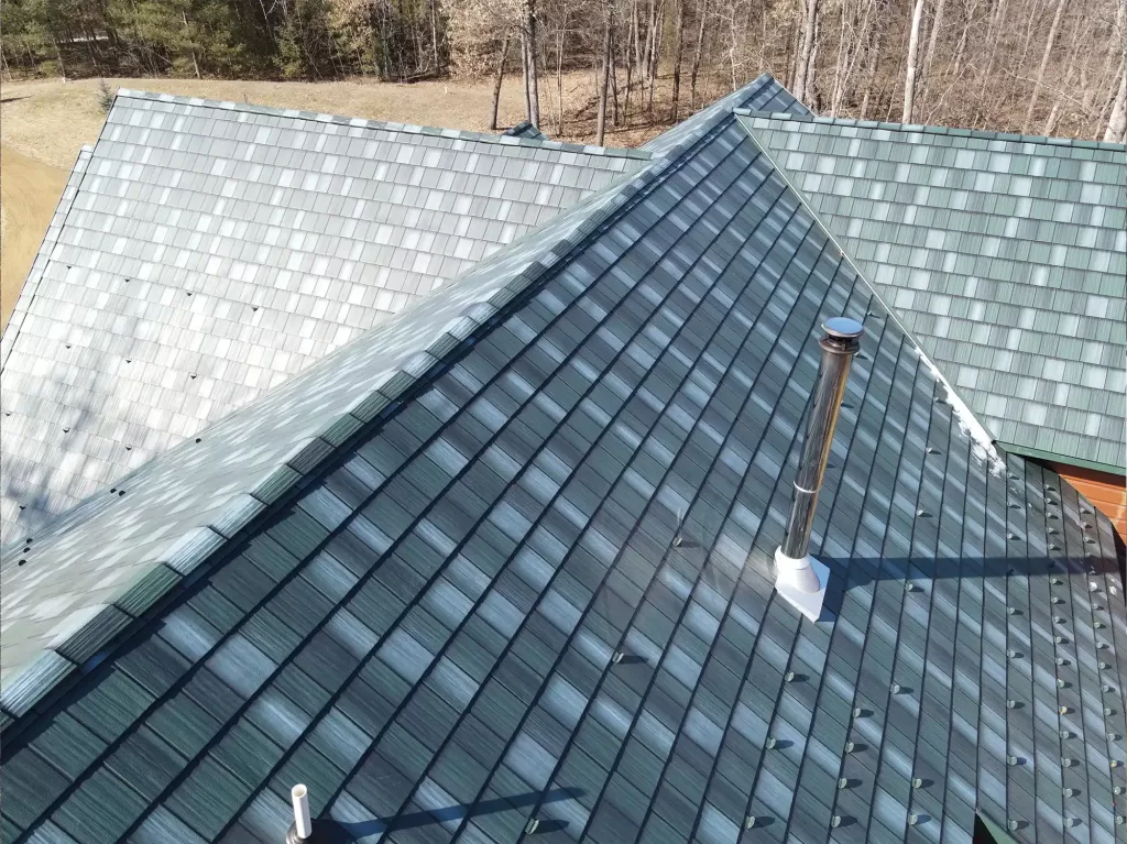 Arial photo of roof with a gray-blue multicolor shingles and metal rod sticking out of roof