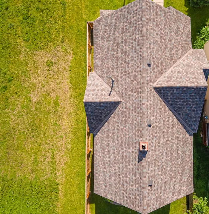 Drone image of brown roof next to green grass