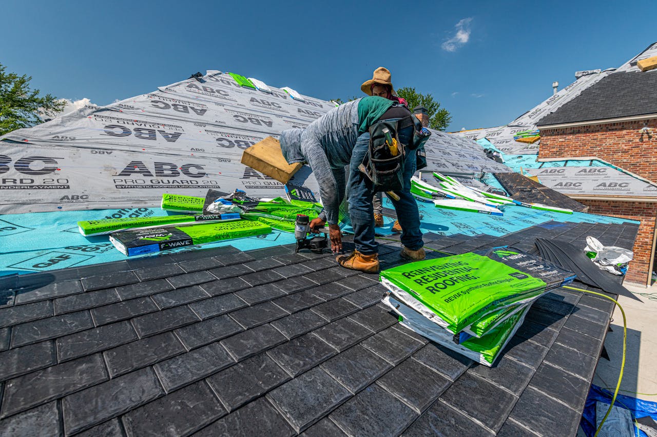 Roofers installing new asphalt shingles showing roof replacement cost factors in Minnesota